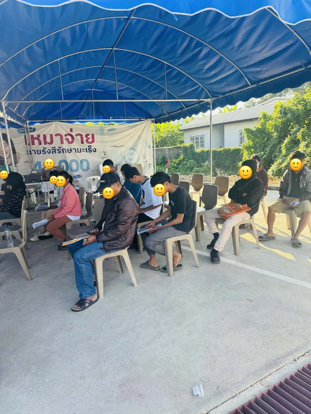 แรงงานต่างด้าวนั่งรอคิวตรวจสุขภาพพร้อมเอกสารประกอบการยื่นใบอนุญาตทำงาน